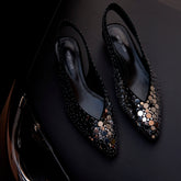 Black studded high-heeled shoes on a dark background