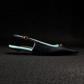 Black and green pointed-toe slingback shoes on a dark background   | Sergio Rossi
